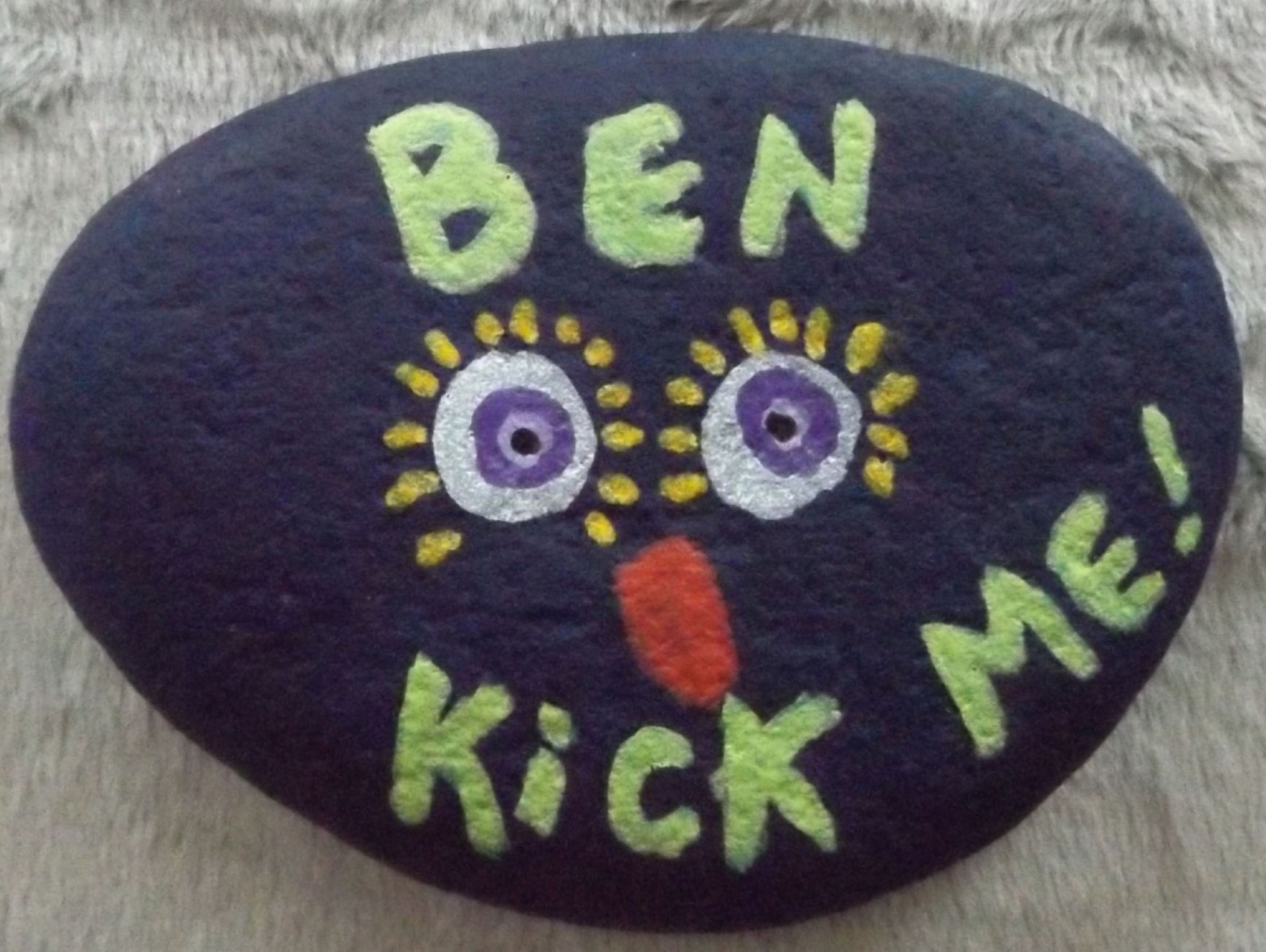 Deep purple rock hand-painted with the name Ben and Kick Me!