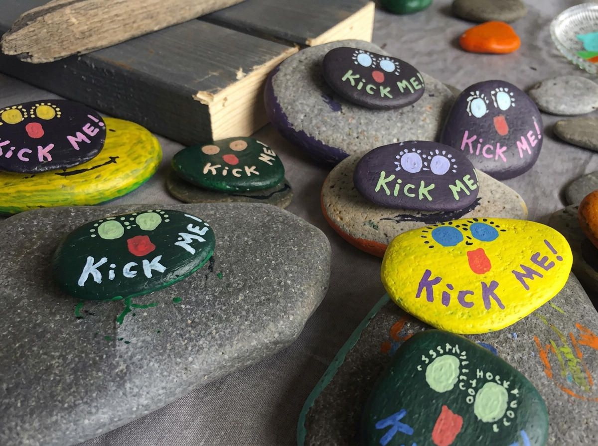 Freshly painted rocks with eyes and Kick Me! lettering